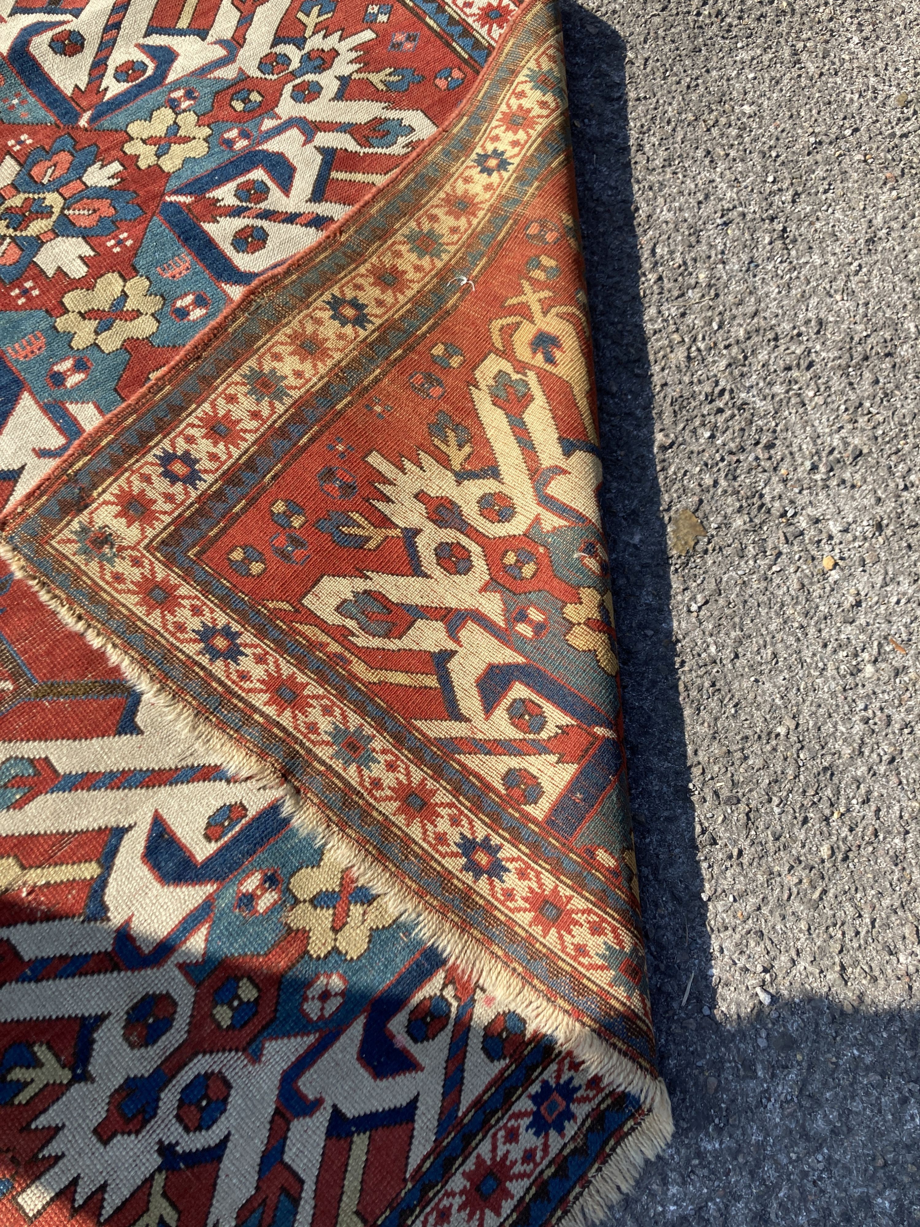 An early 20th century Caucasian “Eagle” Kazak brick red ground rug with triple medallion (altered) 230 x 134 cms.